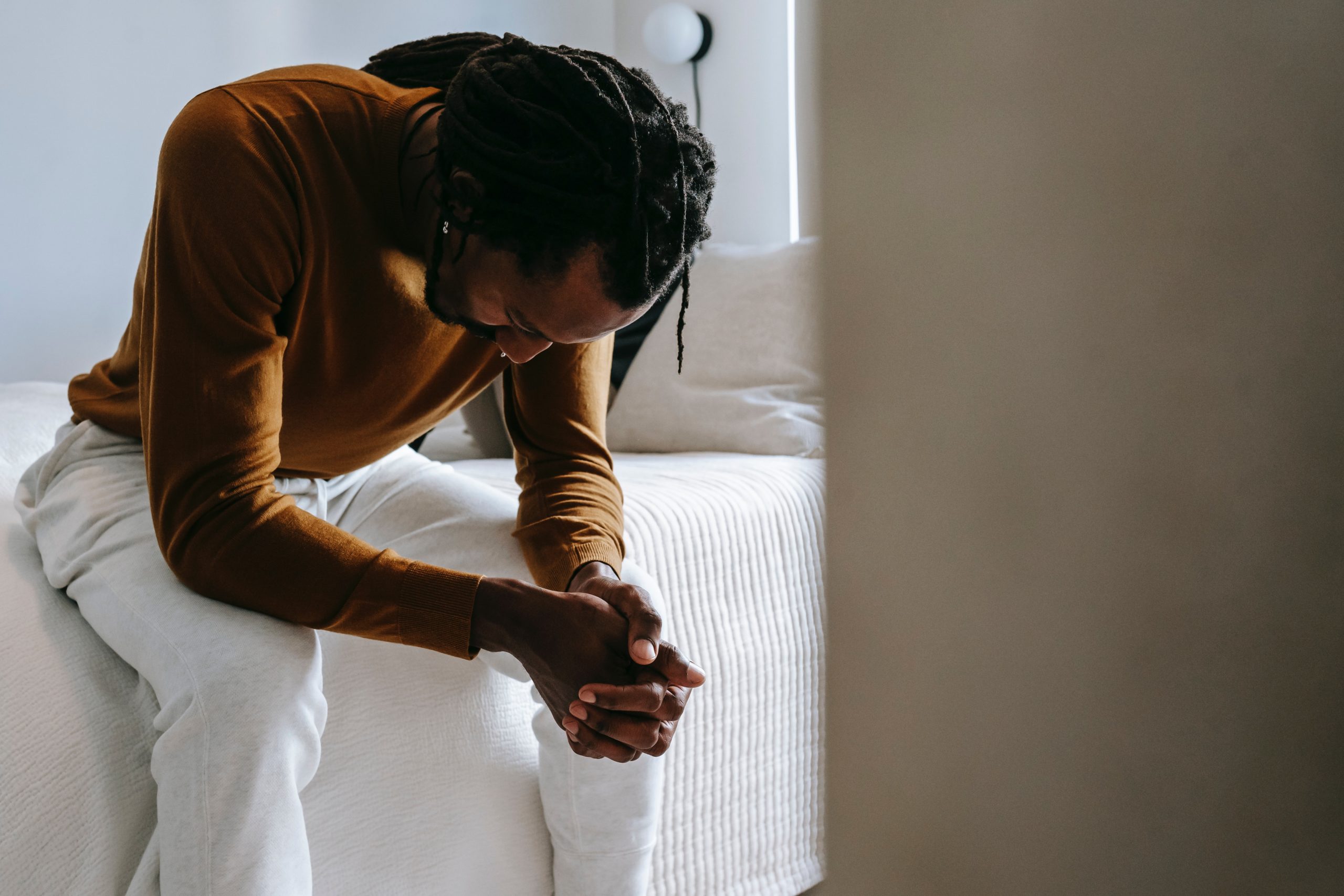 Person sitting on a bed thinking or praying